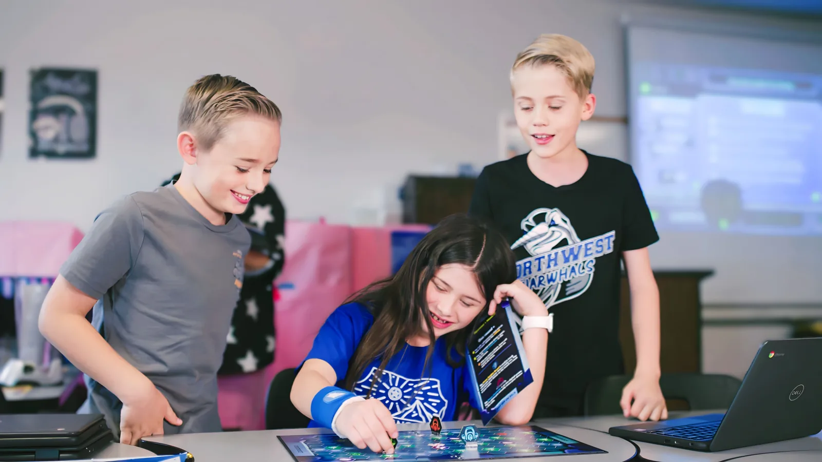Students celebrating around a tall card tower they built
